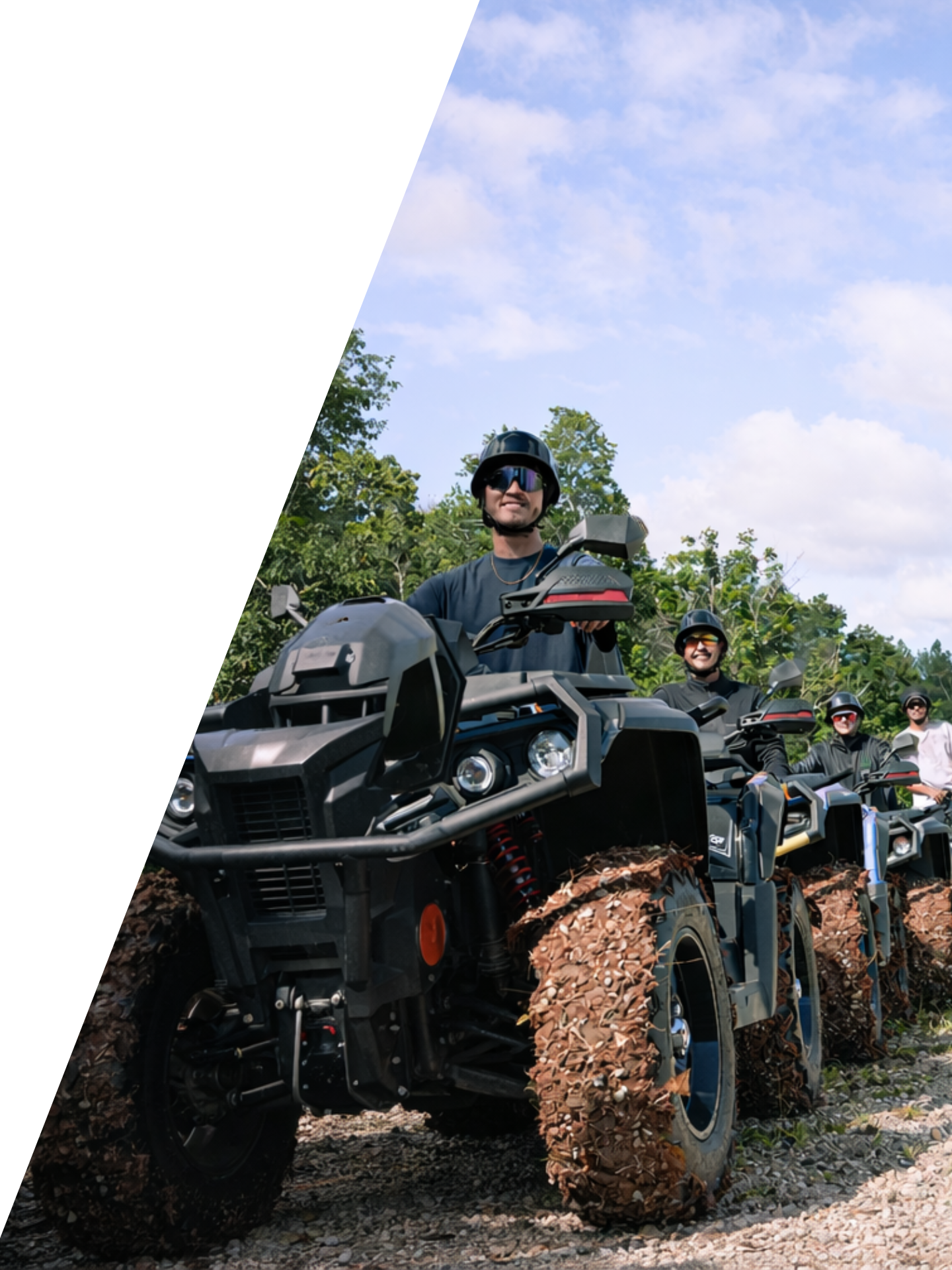 Group of people riding black ATVs on a gravel trail